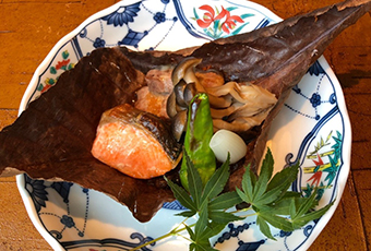 福井サーモンと黒龍吟醸豚の朴葉焼き はまな味噌 花らっきょう添え(コース料理内の一部です)